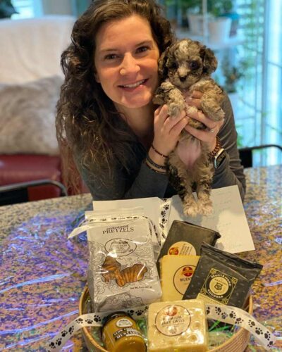 Owner of Jones Farm Puppies holding one of her puppies in front of a food basket